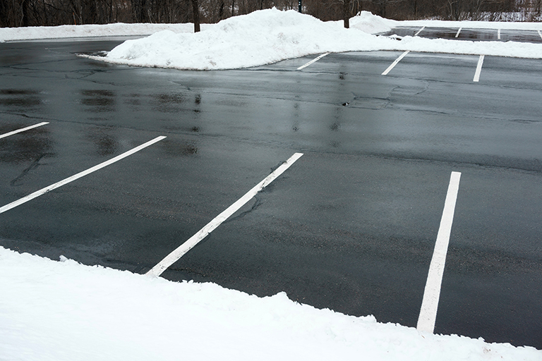 Piles of white snow plowed from blacktop asphalt parking lot | Plan Your Commercial Landscaping Company Projects for 2019 | Hittle Landscape